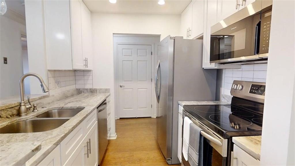 300 Johnson Ferry Road, Unit B201 Atlanta, GA 30328 - Photo 11 of 32 a kitchen with stainless steel appliances granite countertop a sink stove and refrigerator