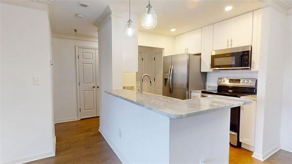 300 Johnson Ferry Road, Unit B201 Atlanta, GA 30328 - Photo 12 of 32 a kitchen with stainless steel appliances a refrigerator sink and microwave