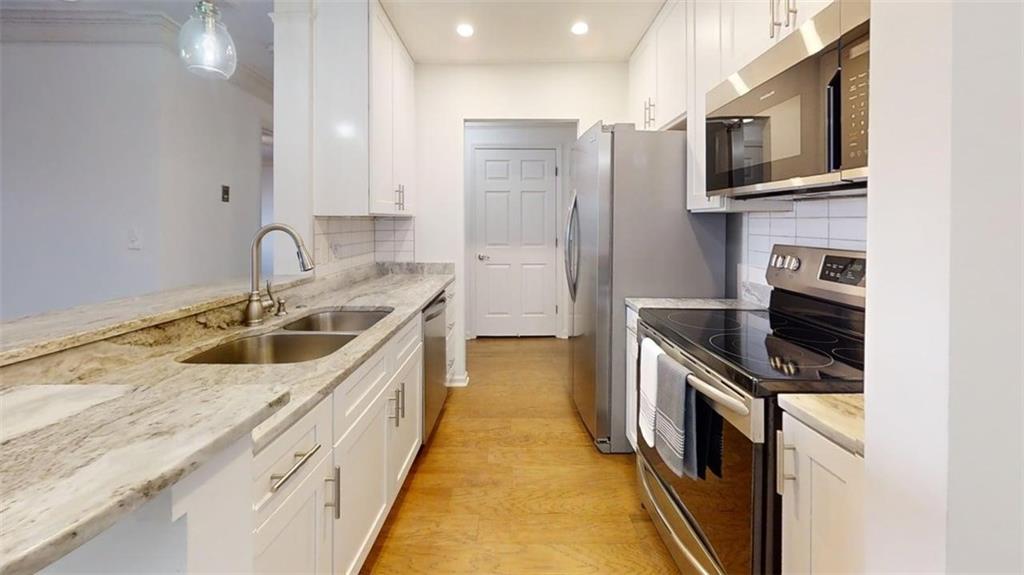 300 Johnson Ferry Road, Unit B201 Atlanta, GA 30328 - Photo 15 of 32 a kitchen with stainless steel appliances granite countertop a sink stove and refrigerator