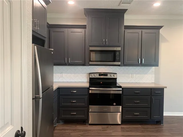 a kitchen with appliances a sink and cabinets