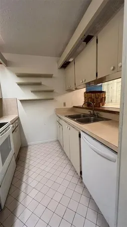 a kitchen with kitchen island granite countertop cabinets and white appliances