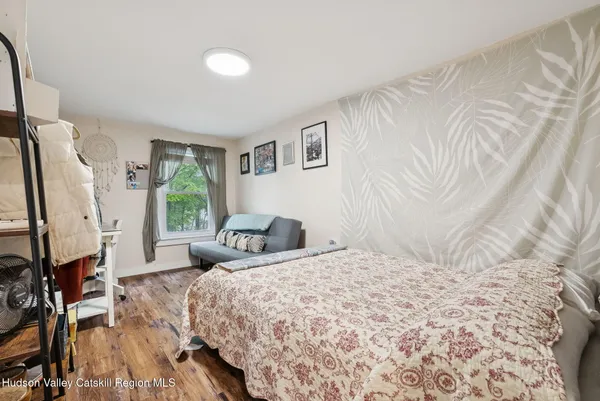 a bedroom with a bed flat screen tv and a window