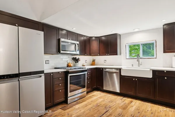 a kitchen with stainless steel appliances granite countertop a sink stove and refrigerator