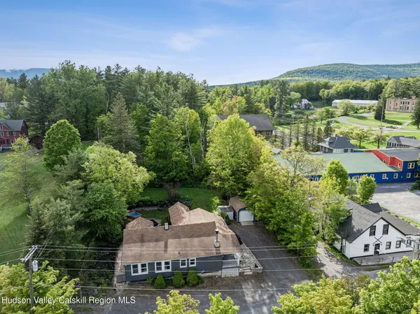 an aerial view of residential house with outdoor space and trees all around