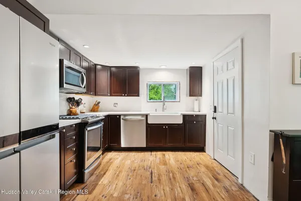 a kitchen with granite countertop a refrigerator stove top oven and sink