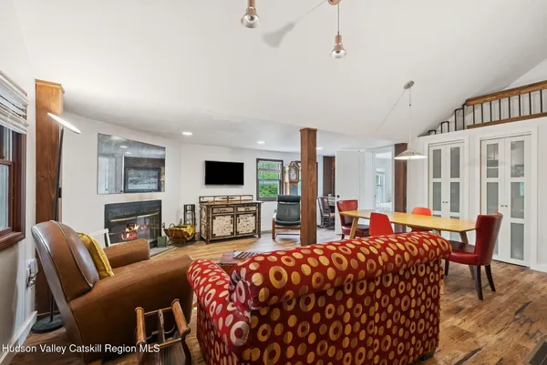 a large living room with furniture a flat screen tv and a fireplace