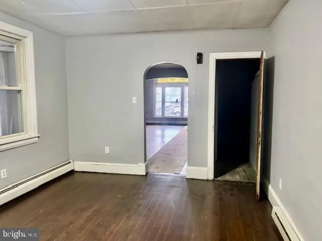 a view of a hallway with wooden floor and a living room