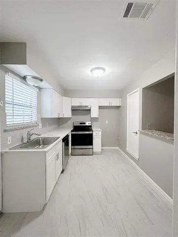 a kitchen with stainless steel appliances a sink and a stove