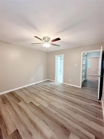 a view of a livingroom with wooden floor and a ceiling fan