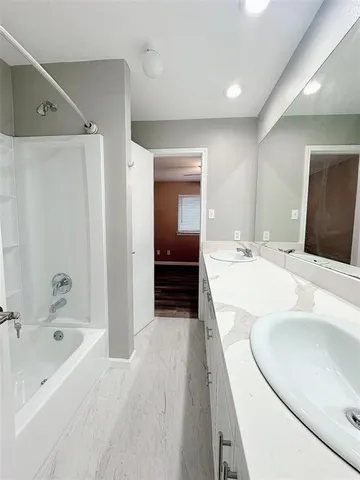 a bathroom with a bathtub sink and a mirror