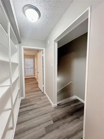a view of a hallway with wooden floor and staircase