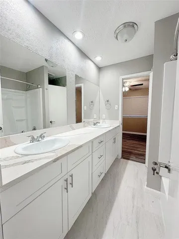 a spacious bathroom with a double vanity sink and mirror