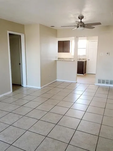 a view of a kitchen with a sink and an empty room