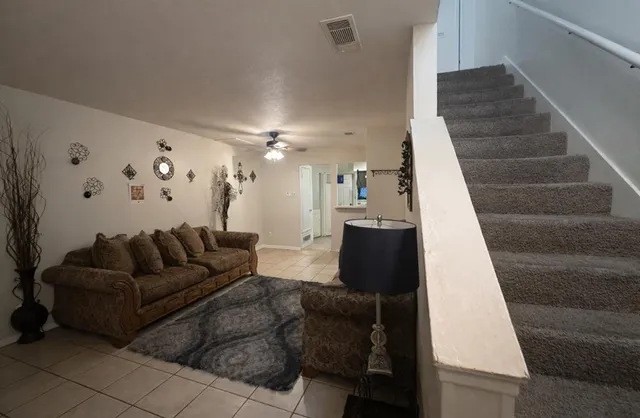 a living room with furniture and stairs