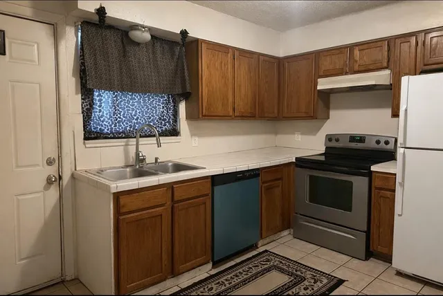 a kitchen with a sink stove and cabinets