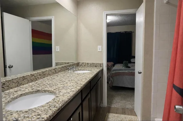 a bathroom with a granite countertop sink and a mirror