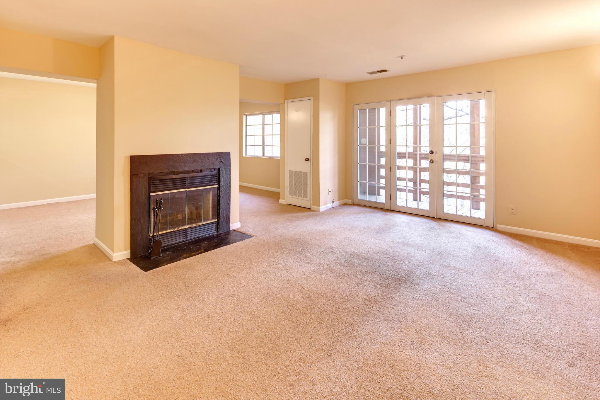 4912 Columbia Road, Unit 6111 Columbia, MD 21044 - Photo 3 of 29 a view of an empty room with a fireplace and a window