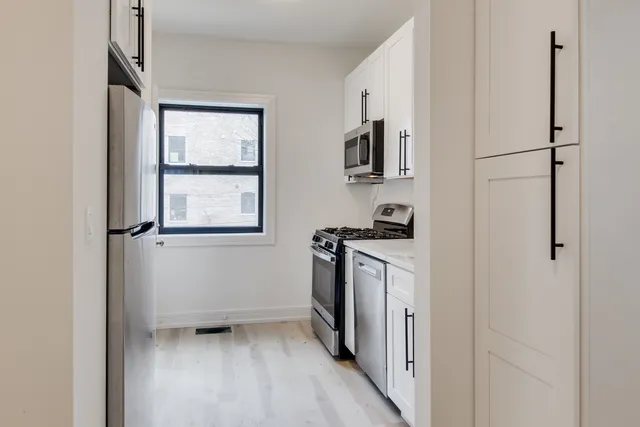 a kitchen with white cabinets and white appliances