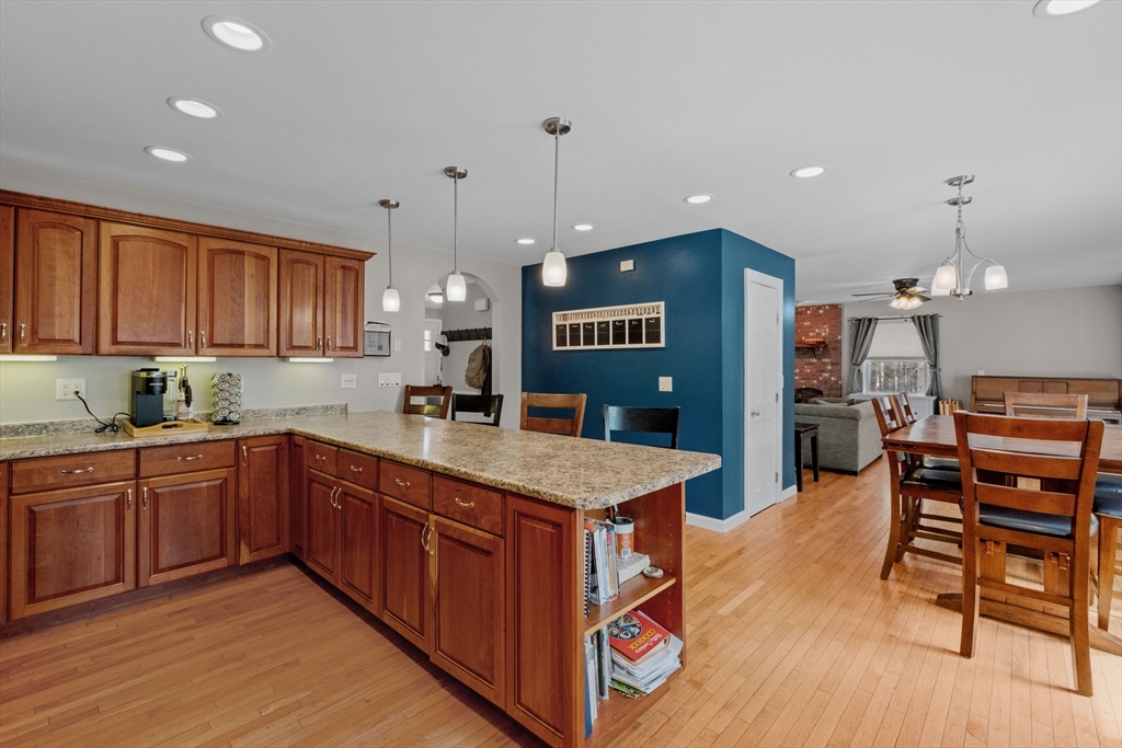 275 Lucas Road Manchester, NH 03109 - Photo 11 of 39 a kitchen with stainless steel appliances granite countertop wooden floors and wooden cabinets