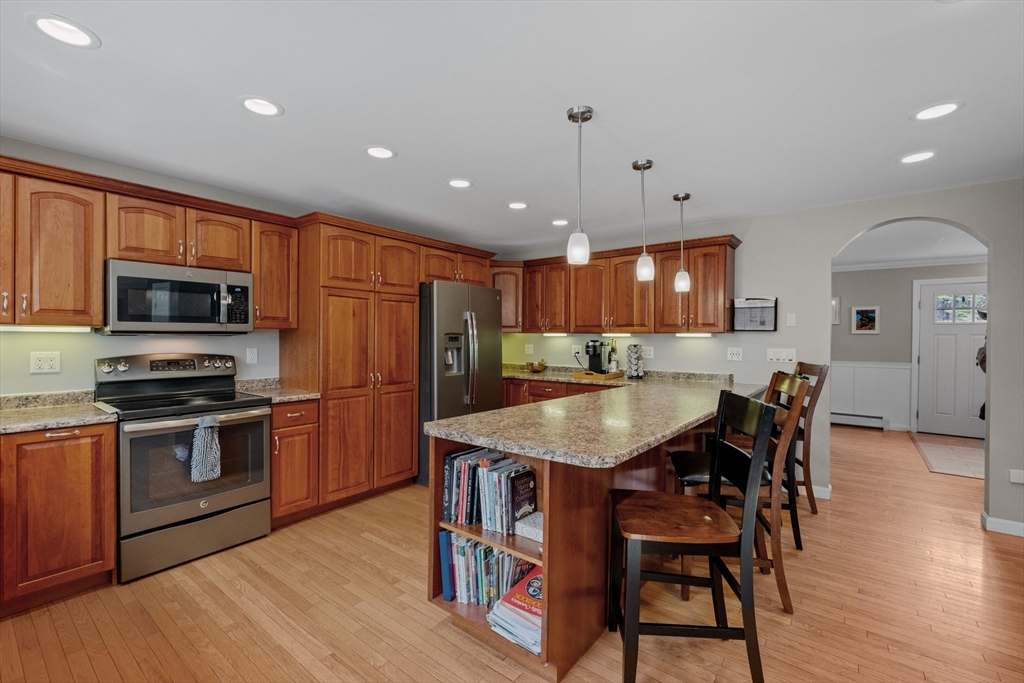 275 Lucas Road Manchester, NH 03109 - Photo 13 of 39 a kitchen with stainless steel appliances granite countertop a kitchen island hardwood floor sink and stove