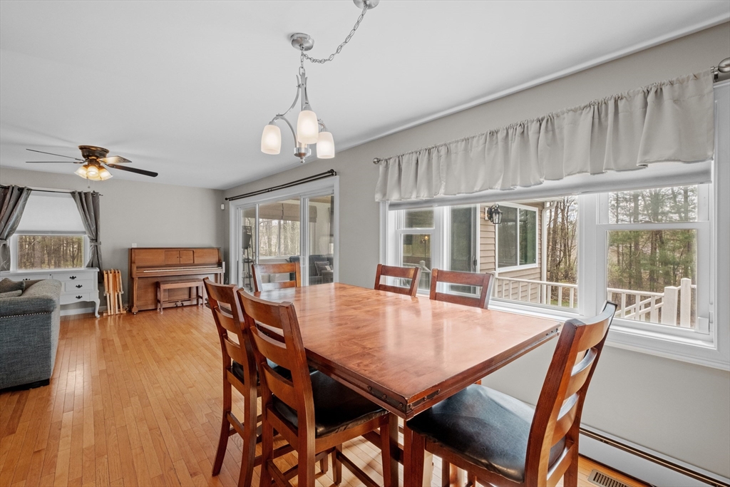 275 Lucas Road Manchester, NH 03109 - Photo 8 of 39 a dining room with wooden floor a chandelier a wooden table and chairs