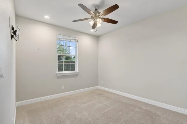 an empty room with windows and fan