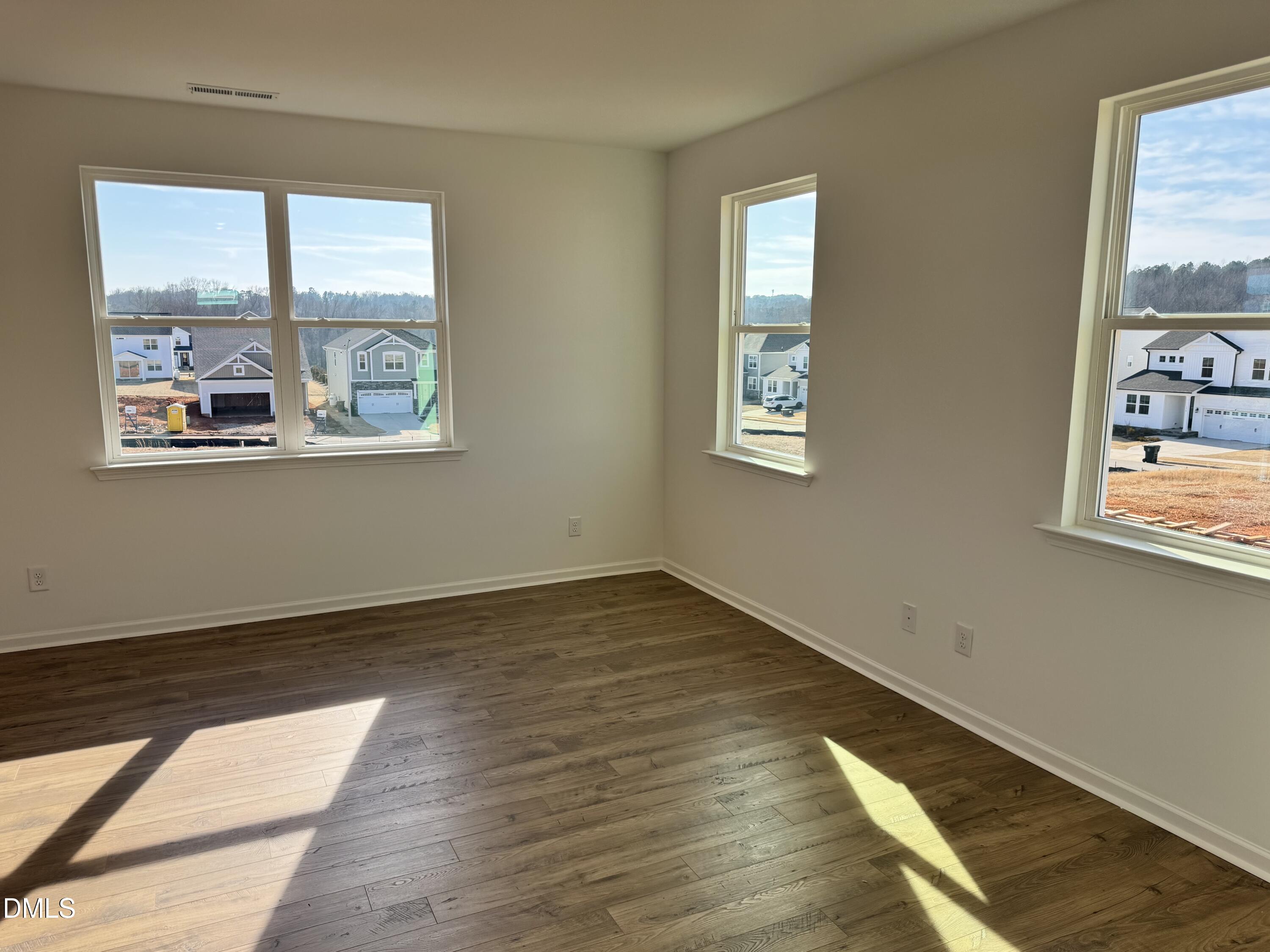 151 Sprenger Street Garner, NC 27529 - Photo 6 of 22 a view of an empty room with wooden floor and a window