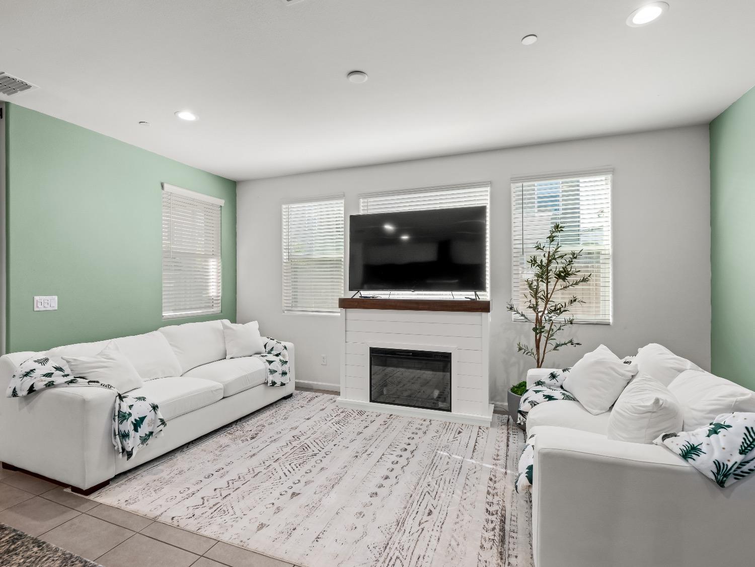 867 Fir Street Madera, CA 93636 - Photo 13 of 39 a living room with furniture a fireplace and a flat screen tv
