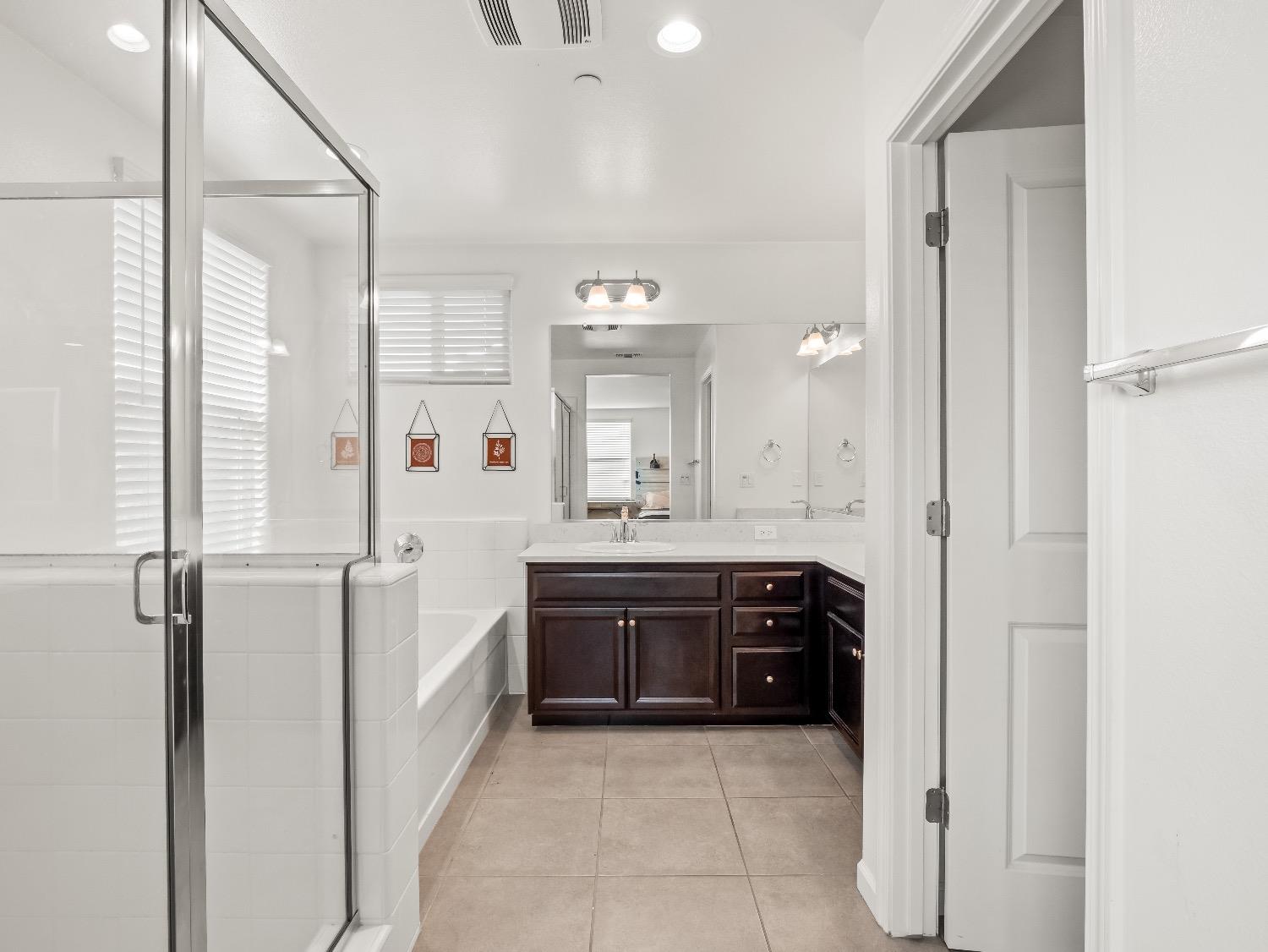 867 Fir Street Madera, CA 93636 - Photo 19 of 39 a spacious bathroom with a bathtub sink and mirror