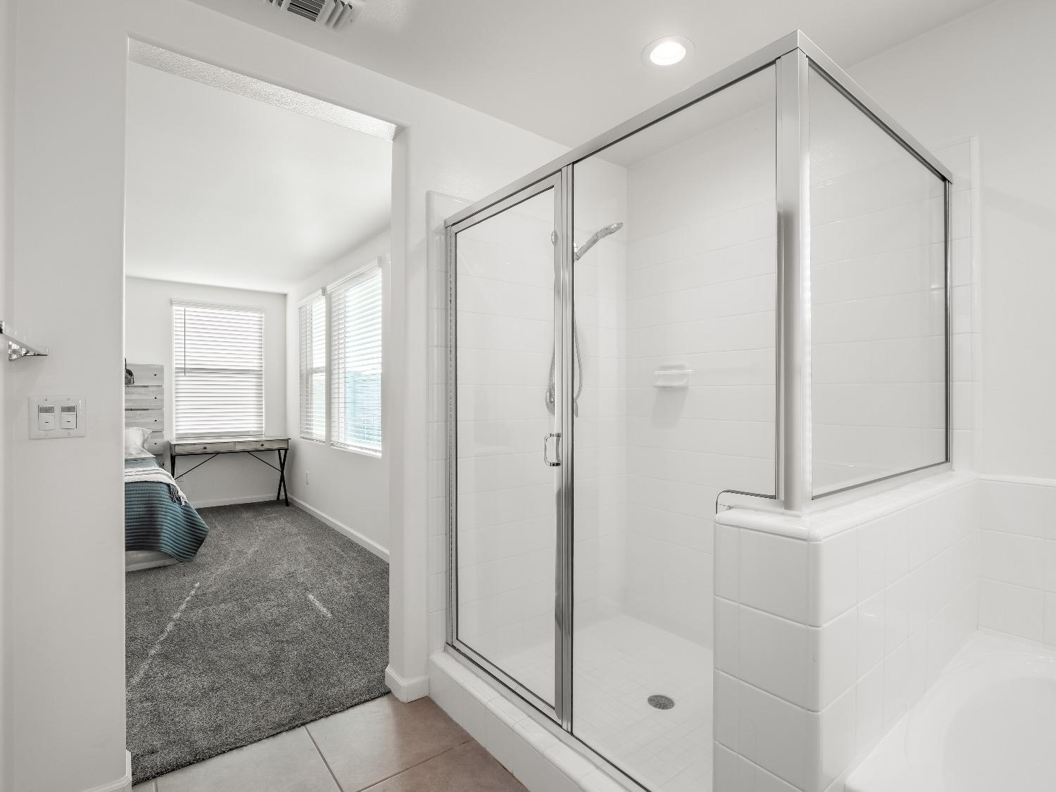 867 Fir Street Madera, CA 93636 - Photo 22 of 39 a bathroom with a glass shower door and a bathtub