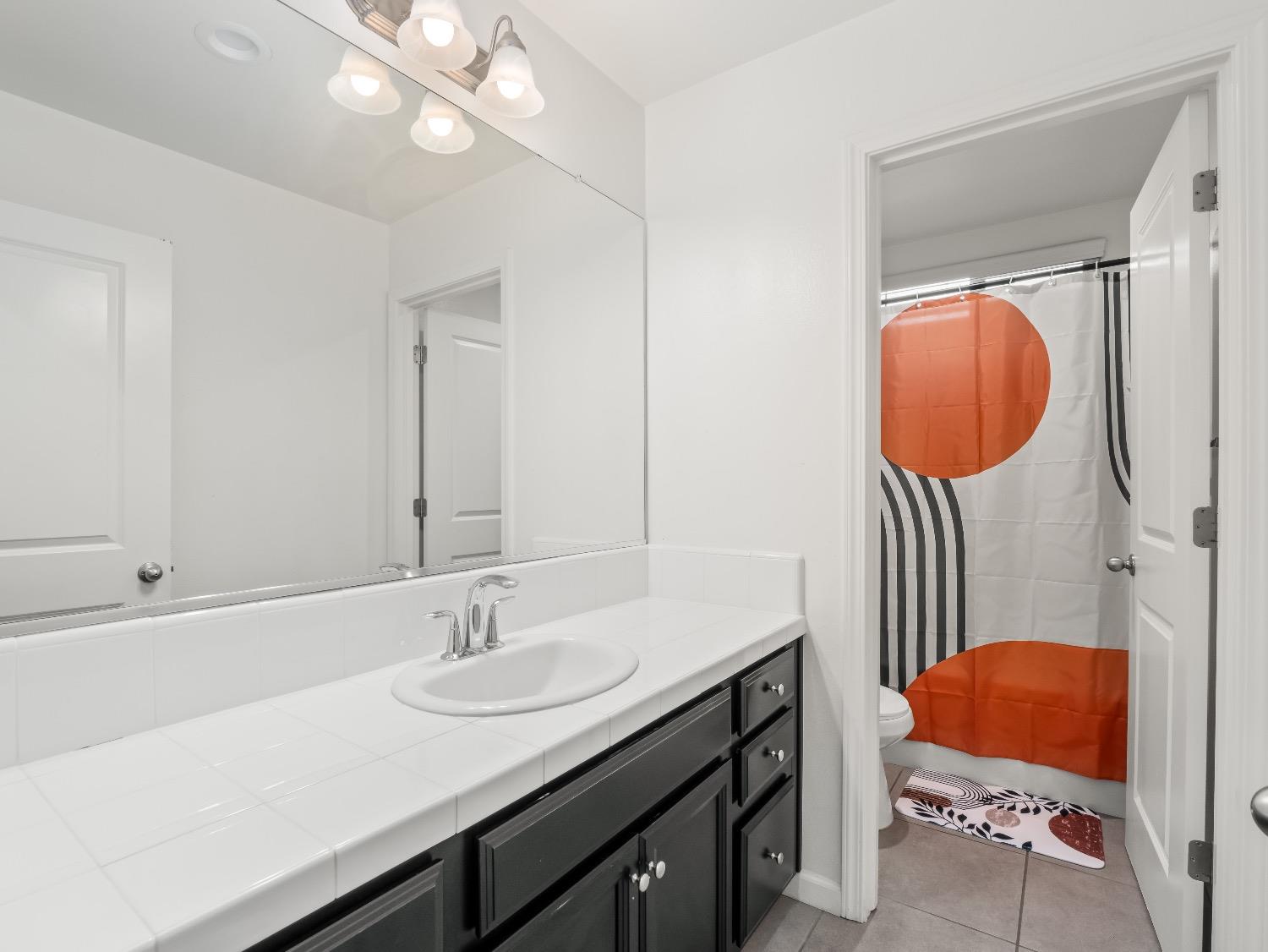 867 Fir Street Madera, CA 93636 - Photo 27 of 39 a bathroom with a sink a toilet and a mirror