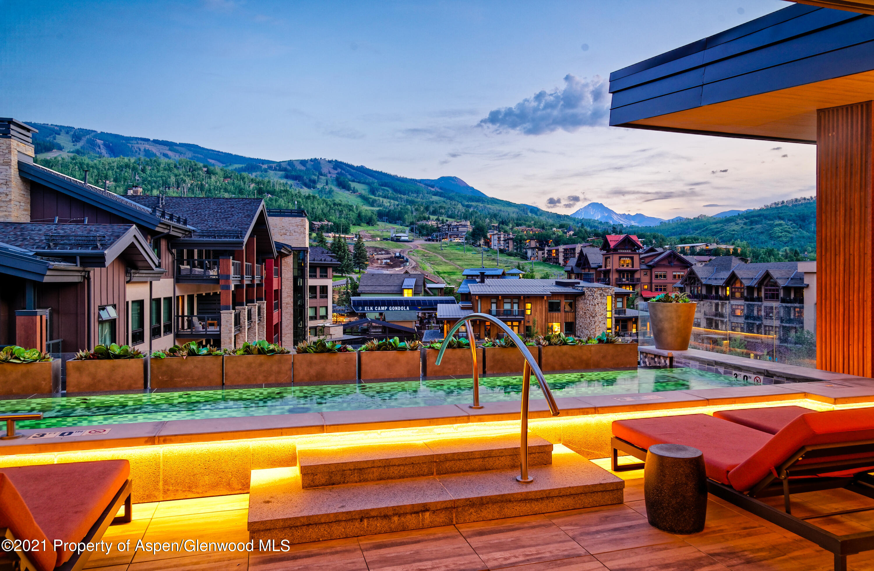 77 Wood Road, Unit 801E Snowmass Village, CO 81615 - Photo 24 of 30 a view of a swimming pool with a lounge chairs in front of a house