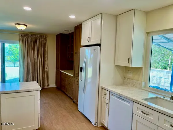 a kitchen with stainless steel appliances granite countertop a refrigerator and a sink