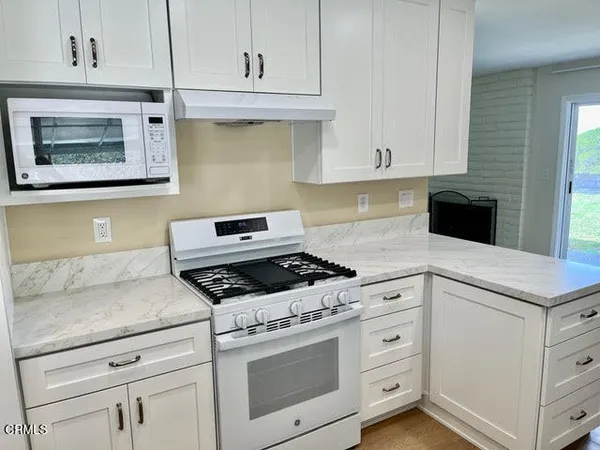 a kitchen with white cabinets and appliances