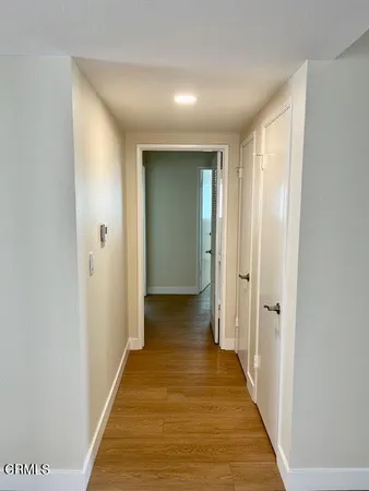 a view of a hallway with wooden floor