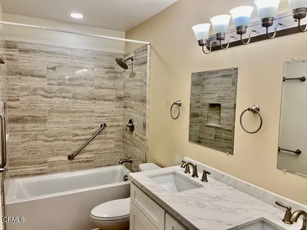 a bathroom with a granite countertop sink toilet and shower