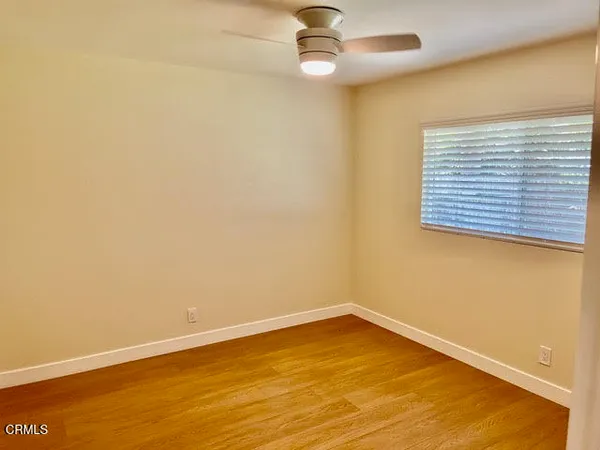 an empty room with a window and ceiling fan