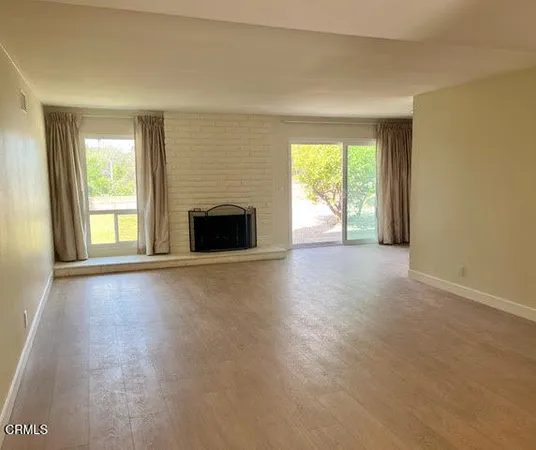an empty room with windows and a fireplace