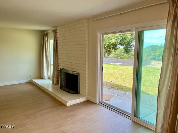 a view of an empty room with a fireplace and a window