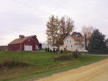 a view of a large house with a big yard and large trees