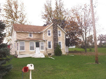 7427 East Maize Road Ridott, IL 61067 - Photo 5 of 5 a front view of a house with a garden and yard