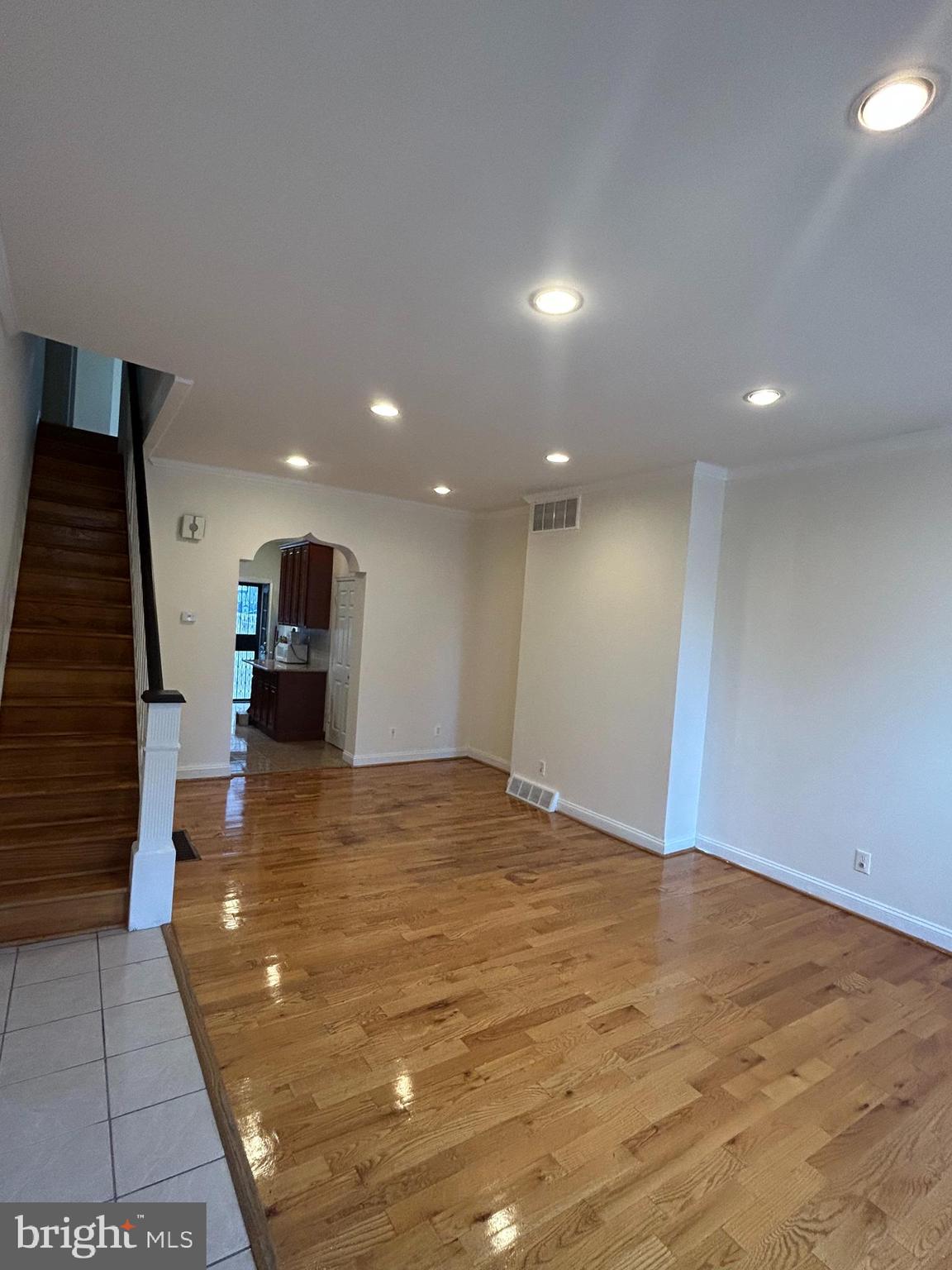 a view of an empty room with wooden floor