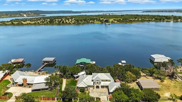 an aerial view of a house with a yard and lake view