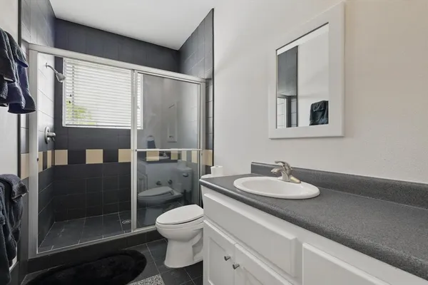 a bathroom with a granite countertop sink toilet and shower