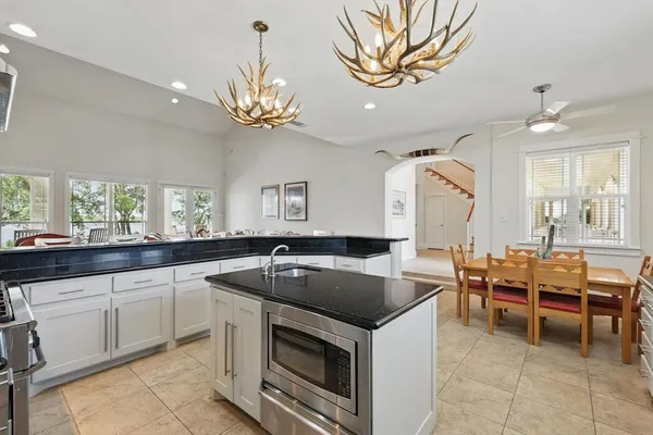 a kitchen that has a sink a stove and chairs