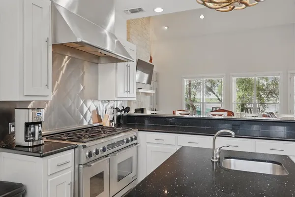 a kitchen with granite countertop a stove and a sink