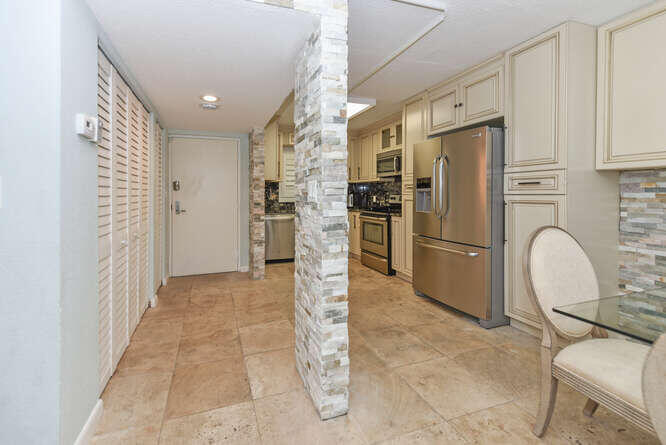 420 Celestial Way, Unit 101 Juno Beach, FL 33408 - Photo 12 of 37 a kitchen with refrigerator and furniture