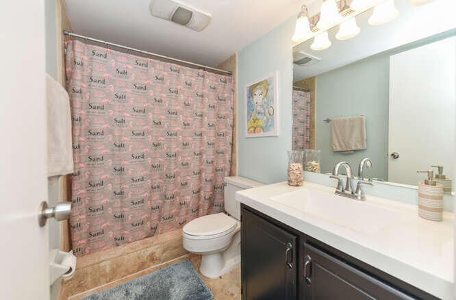 420 Celestial Way, Unit 101 Juno Beach, FL 33408 - Photo 23 of 37 a bathroom with a sink a toilet and shower curtain