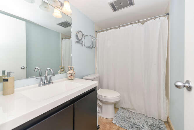 420 Celestial Way, Unit 101 Juno Beach, FL 33408 - Photo 25 of 37 a bathroom with a sink a toilet and a mirror