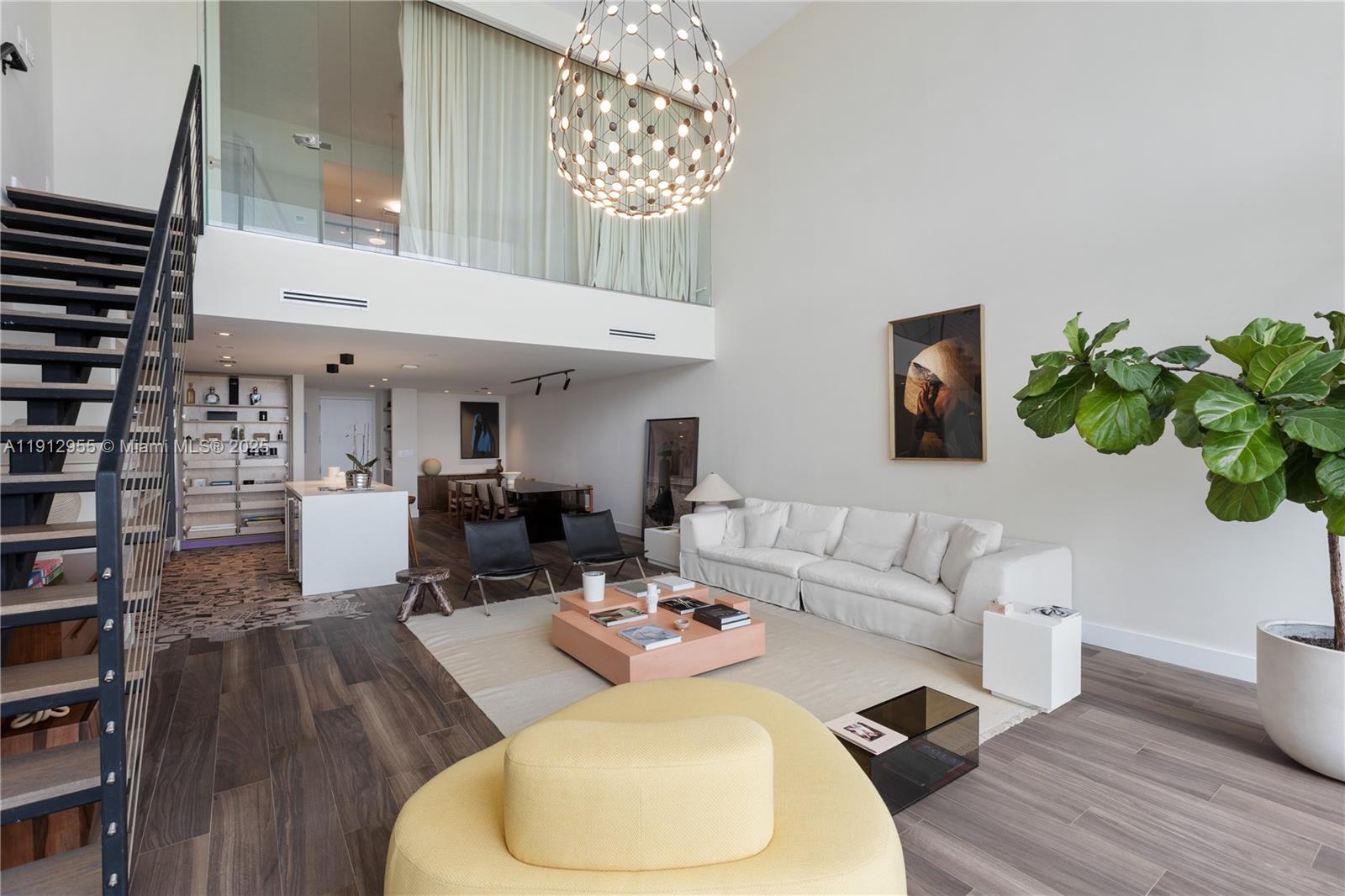 1040 Biscayne Boulevard, Unit 1602 Miami, FL 33132 - Photo 13 of 39 a living room with furniture and a chandelier